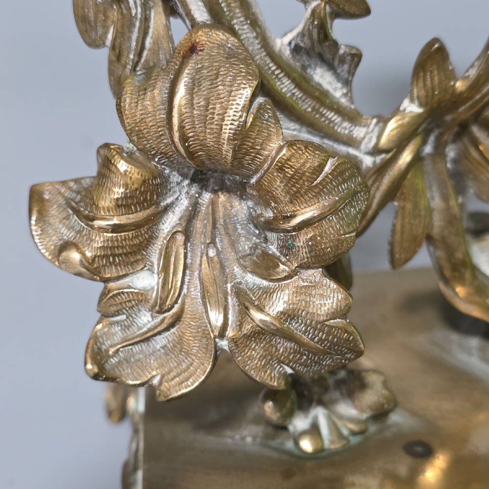 A pair of 19th-century French Napoleon III cast brass candlesticks featuring ornate scrolling leaf motifs and rectangular bases. View XI