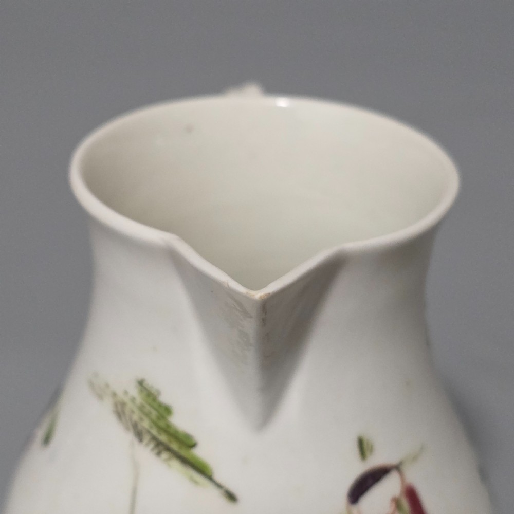 An 18th-century Worcester porcelain sparrow beak cream jug of baluster form, hand-painted with polychrome enamel figures and foliage. View IX