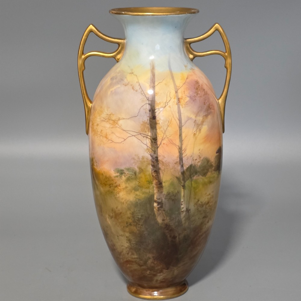 A tall porcelain vase featuring twin gilded handles and a handpainted landscape scene depicting Windsor Castle against a soft sunset sky. View IV