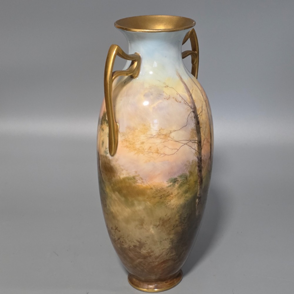 A tall porcelain vase featuring twin gilded handles and a handpainted landscape scene depicting Windsor Castle against a soft sunset sky. View V