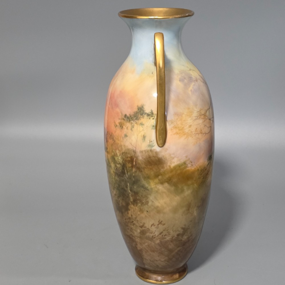 A tall porcelain vase featuring twin gilded handles and a handpainted landscape scene depicting Windsor Castle against a soft sunset sky. View VI