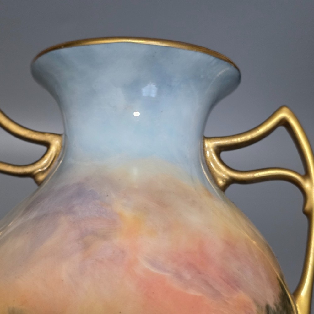 A tall porcelain vase featuring twin gilded handles and a handpainted landscape scene depicting Windsor Castle against a soft sunset sky. View XI