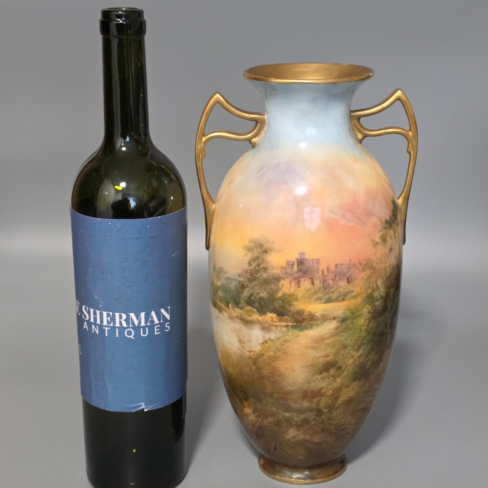 A tall porcelain vase featuring twin gilded handles and a handpainted landscape scene depicting Windsor Castle against a soft sunset sky. View XVII