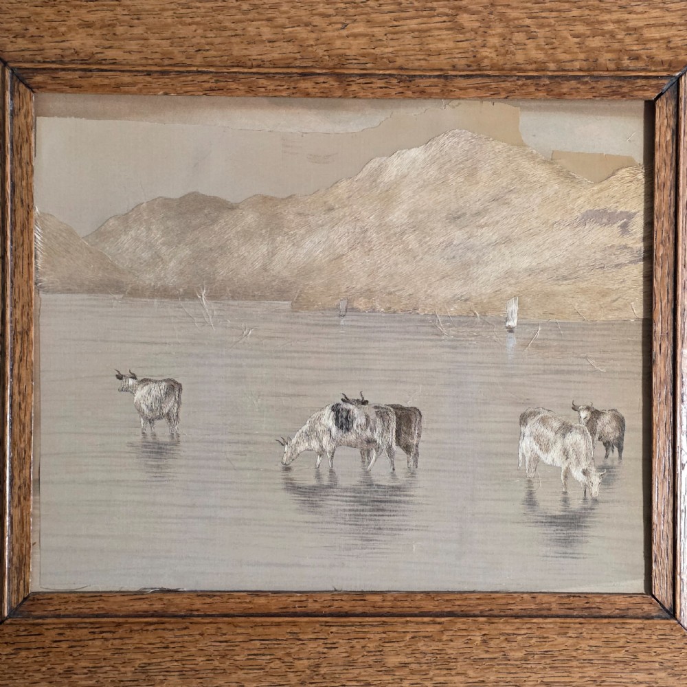 A framed Chinese silk embroidery panel depicting cattle standing in water in front of a mountainous background, presented in a wide oak frame. View III