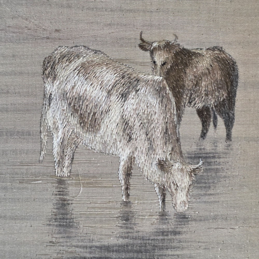 A framed Chinese silk embroidery panel depicting cattle standing in water in front of a mountainous background, presented in a wide oak frame. View VI