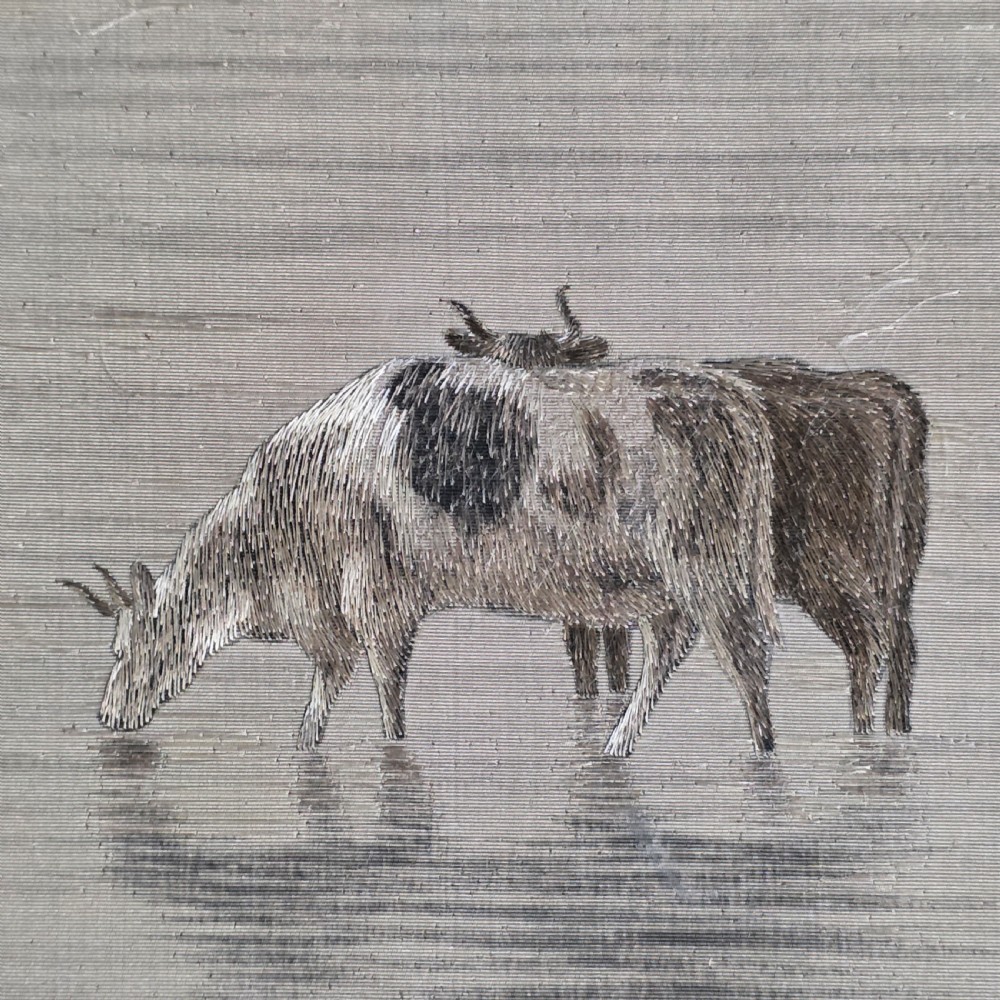 A framed Chinese silk embroidery panel depicting cattle standing in water in front of a mountainous background, presented in a wide oak frame. View IX