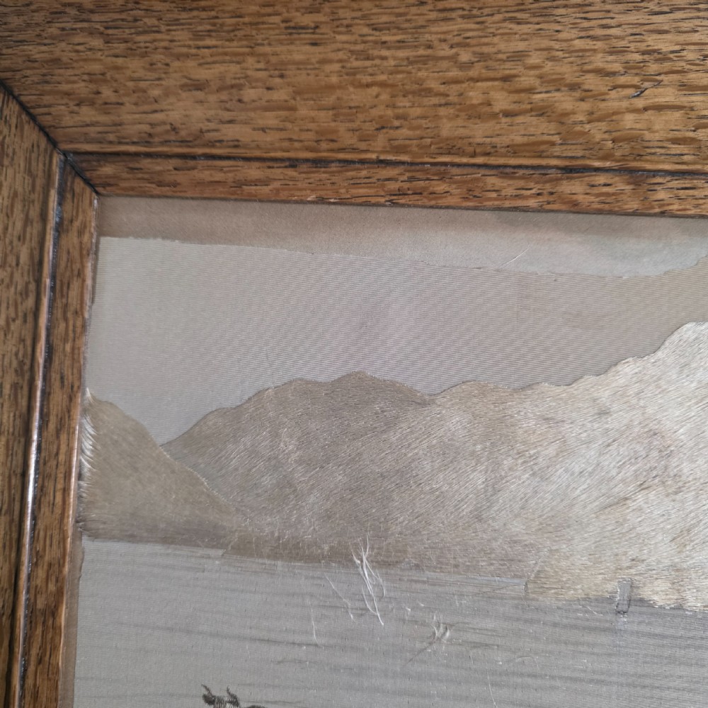 A framed Chinese silk embroidery panel depicting cattle standing in water in front of a mountainous background, presented in a wide oak frame. View XIV