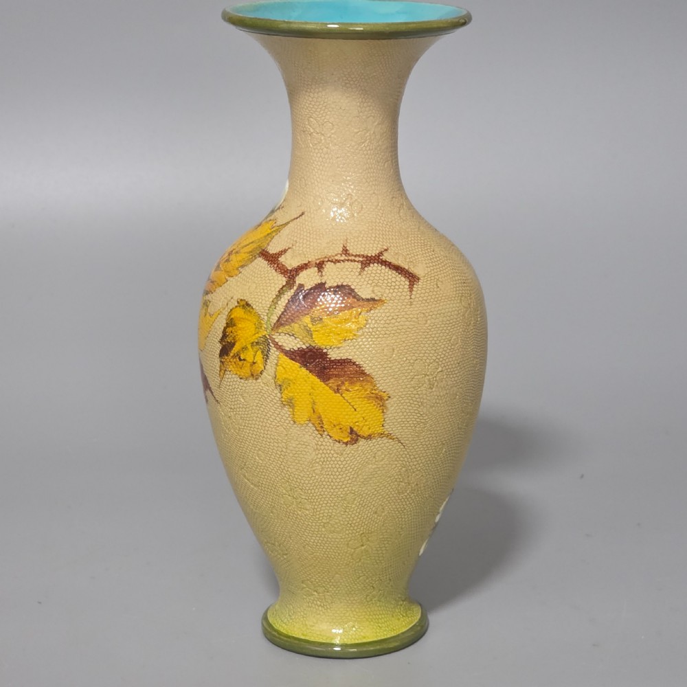 A baluster-shaped Doulton Lambeth ceramic vase featuring a textured lace-patterned buff background painted with botanical autumn leaves and blackberries, finished with a bright turquoise interior rim. View III
