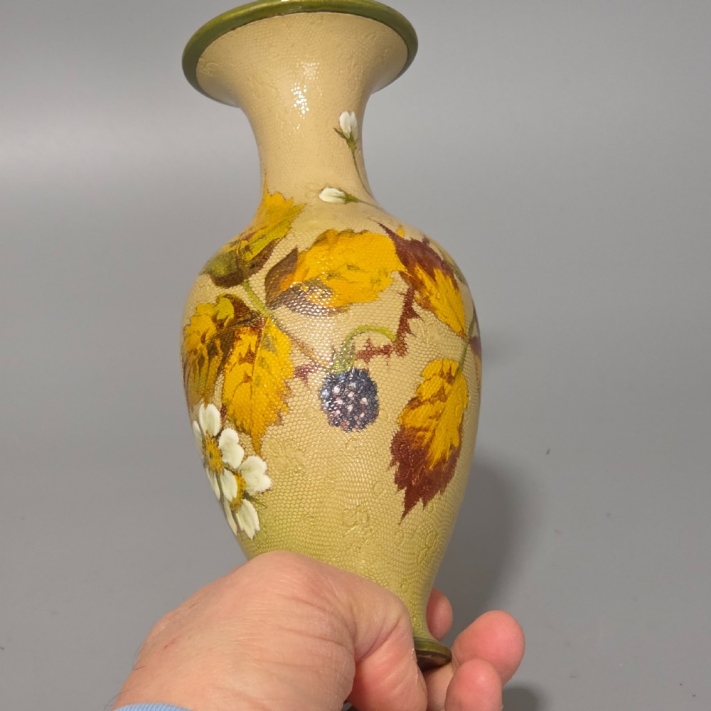 A baluster-shaped Doulton Lambeth ceramic vase featuring a textured lace-patterned buff background painted with botanical autumn leaves and blackberries, finished with a bright turquoise interior rim. View VI
