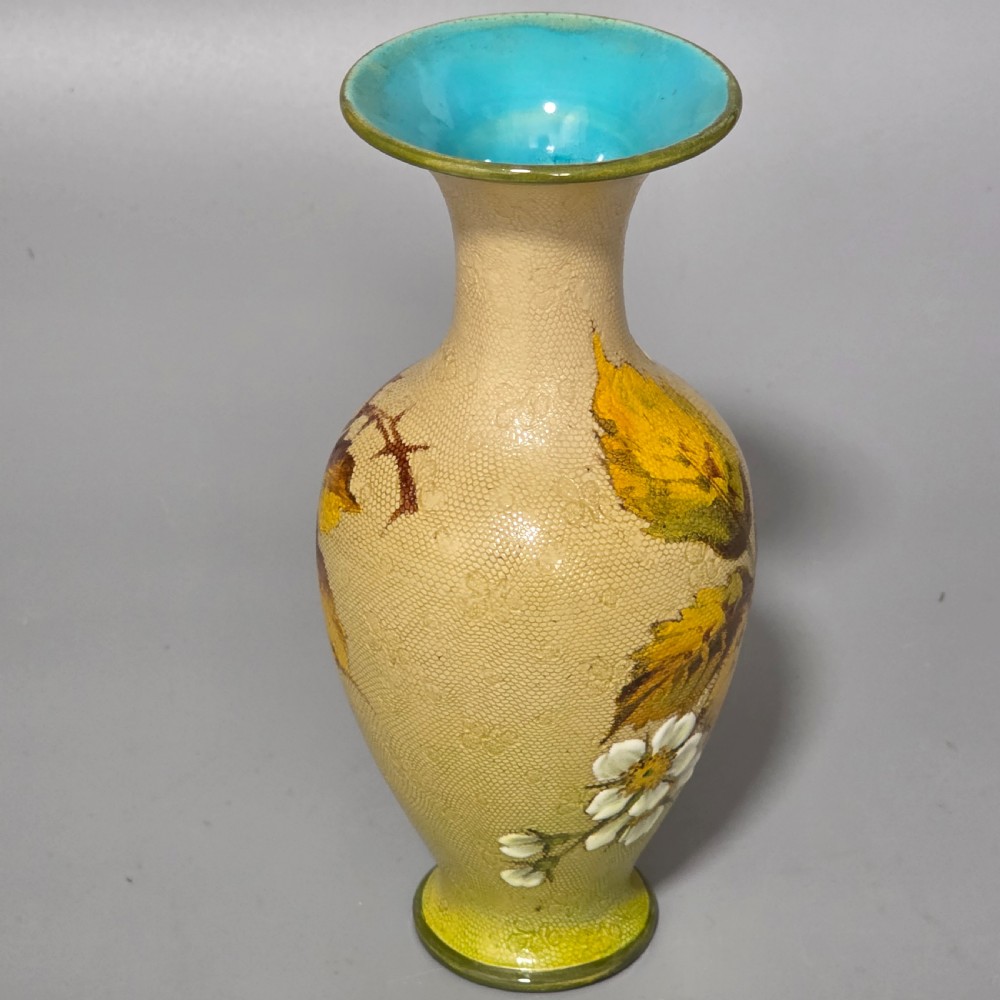 A baluster-shaped Doulton Lambeth ceramic vase featuring a textured lace-patterned buff background painted with botanical autumn leaves and blackberries, finished with a bright turquoise interior rim. View VIII