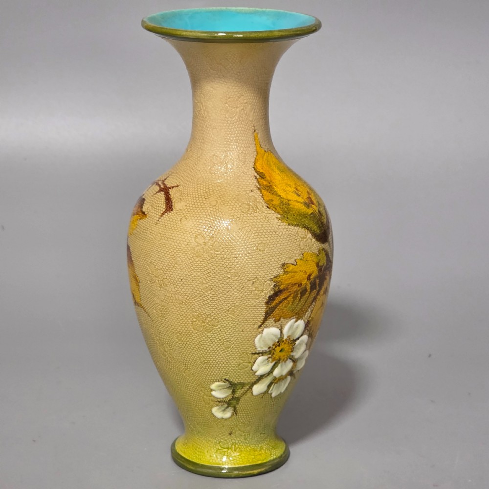 A baluster-shaped Doulton Lambeth ceramic vase featuring a textured lace-patterned buff background painted with botanical autumn leaves and blackberries, finished with a bright turquoise interior rim. View IX
