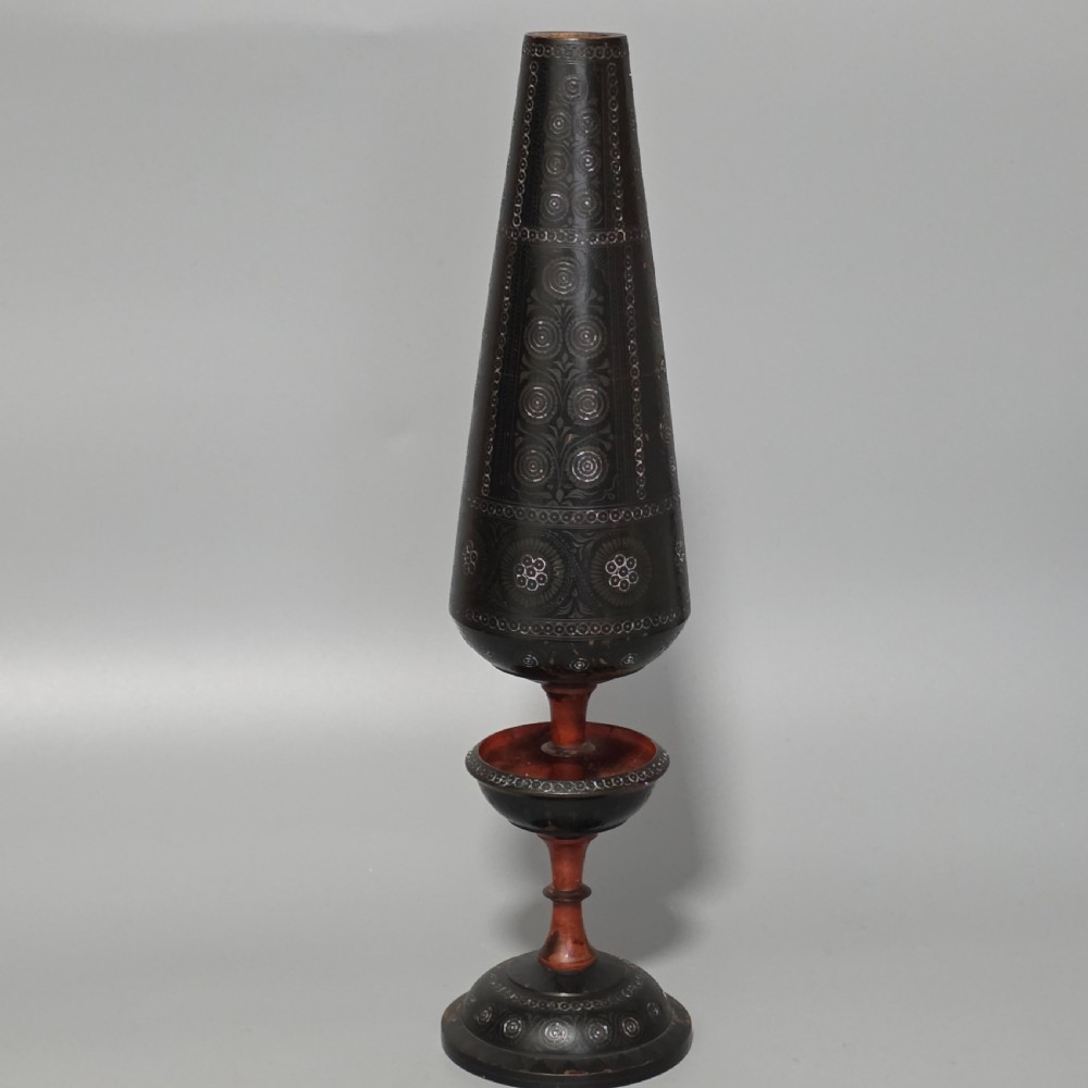 A tall 19th-century lacquered tapering vase with intricate incised geometric motifs on a turned pedestal stem.