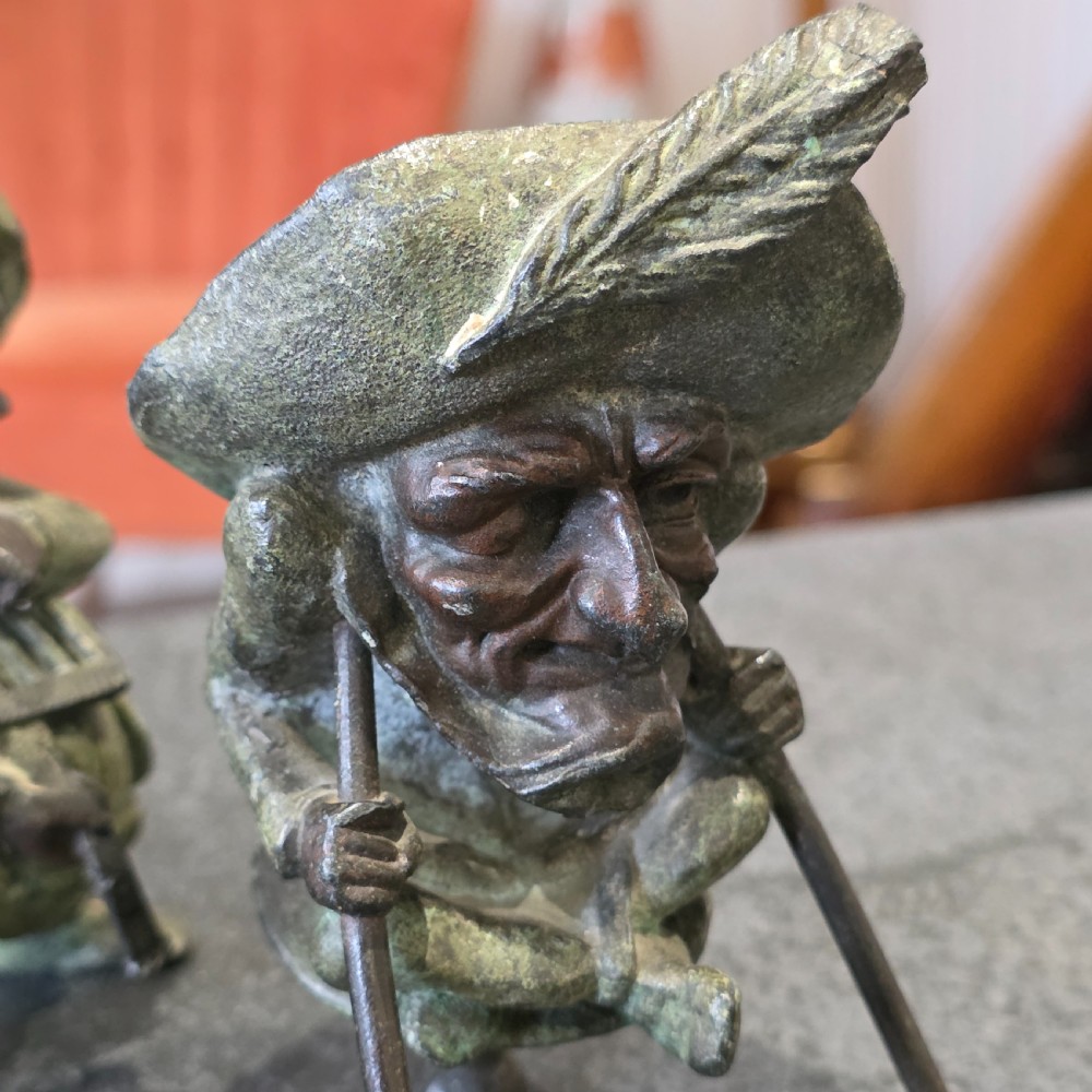 A pair of early twentieth-century French patinated bronze candle holders cast in the form of grotesque satirical caricature figures. View X