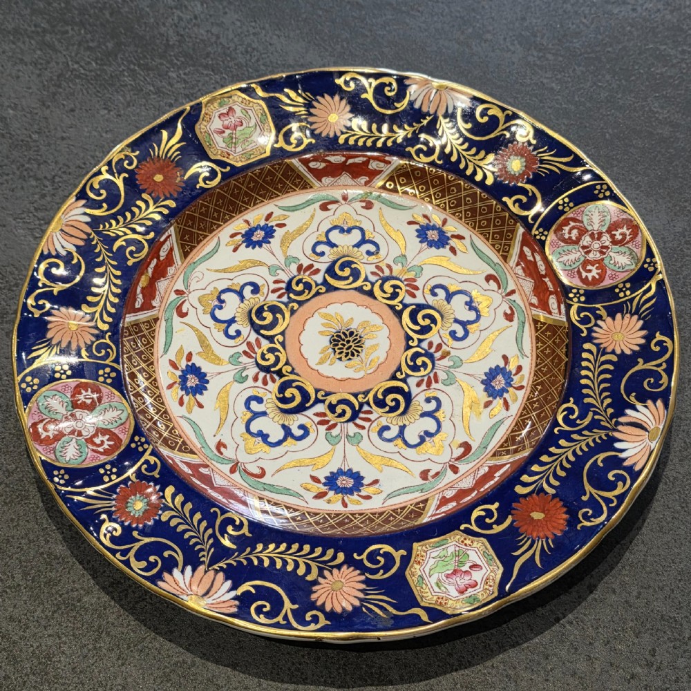 A circular Victorian Ashworth ironstone plate decorated with a rich cobalt blue rim, intricate gilt foliage, and a central Imari floral motif in iron red, blue, and gold. View III
