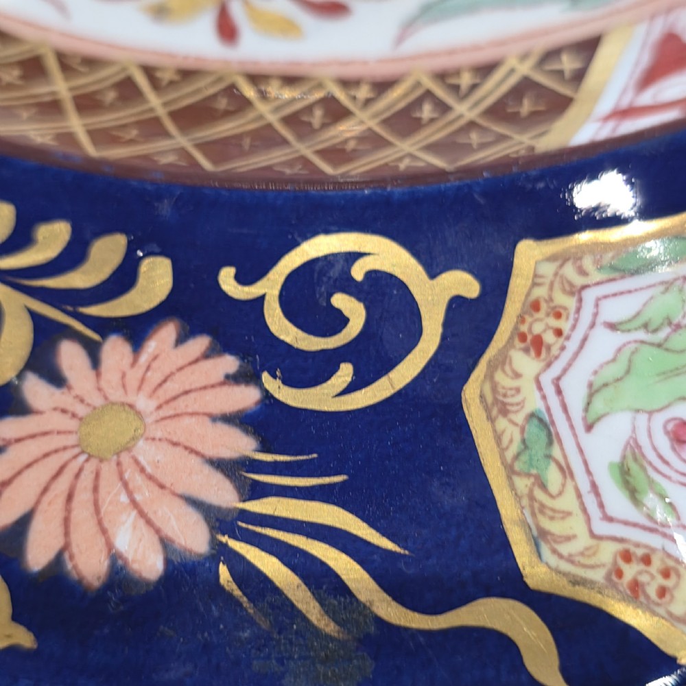 A circular Victorian Ashworth ironstone plate decorated with a rich cobalt blue rim, intricate gilt foliage, and a central Imari floral motif in iron red, blue, and gold. View V