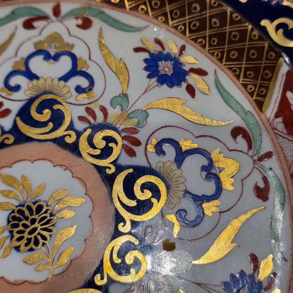 A circular Victorian Ashworth ironstone plate decorated with a rich cobalt blue rim, intricate gilt foliage, and a central Imari floral motif in iron red, blue, and gold. View VIII