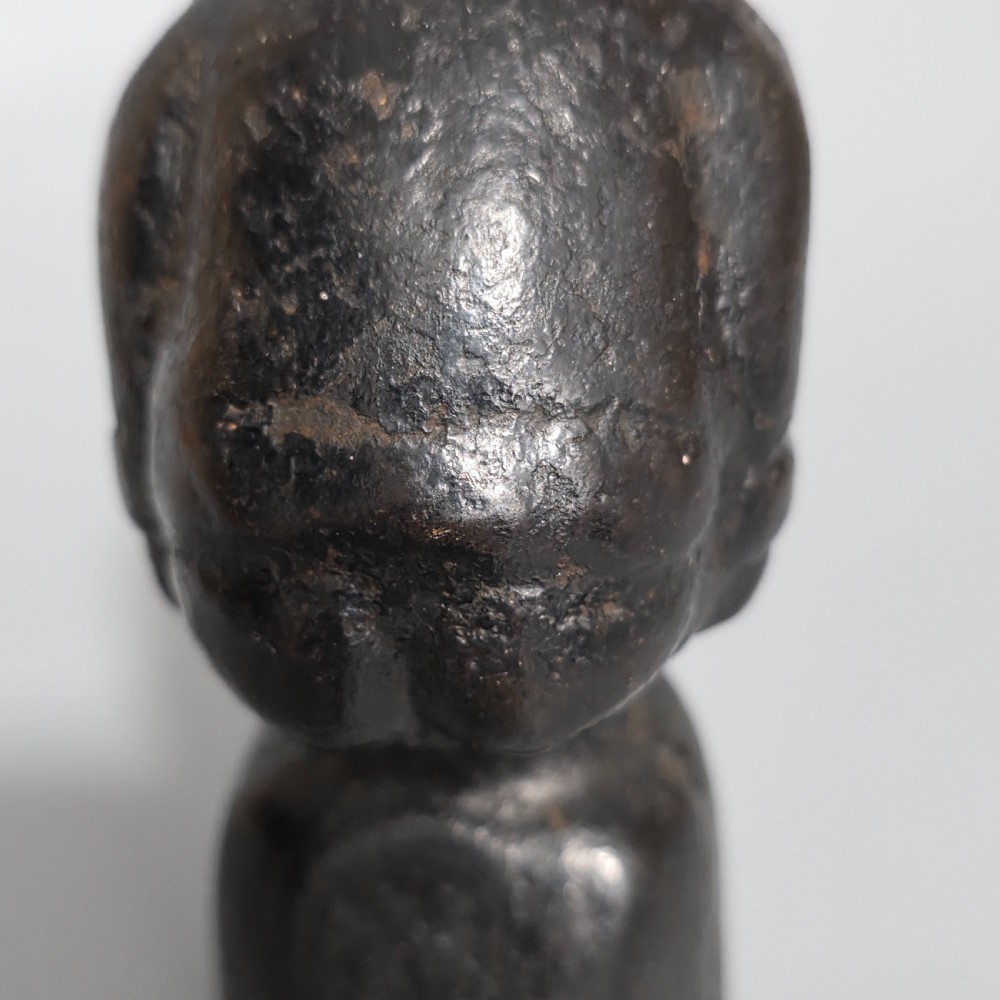 A nineteenth-century dark cast iron paperweight shaped as a crouching male figure in a hat set upon a cylindrical pedestal. View VII