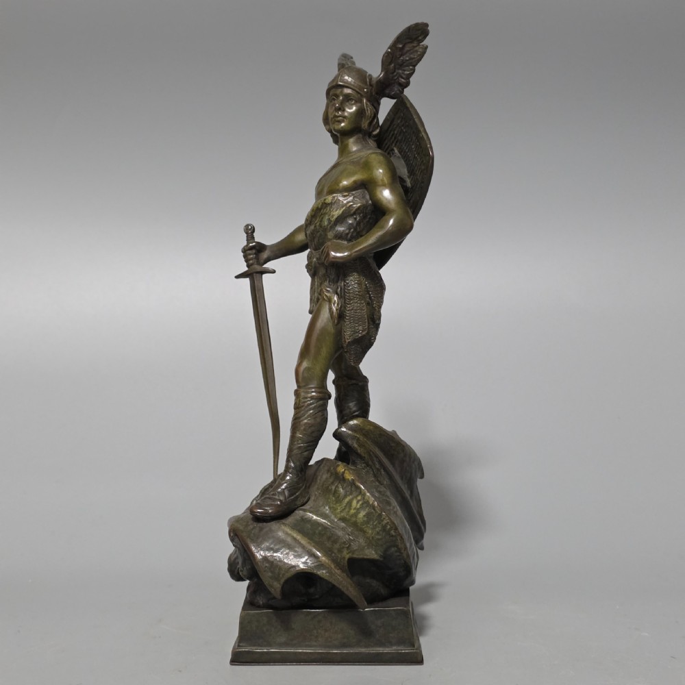 A patinated bronze sculpture depicting the mythical hero Siegfried standing victorious with a sword, winged helmet, and shield above a dragon base. View IX