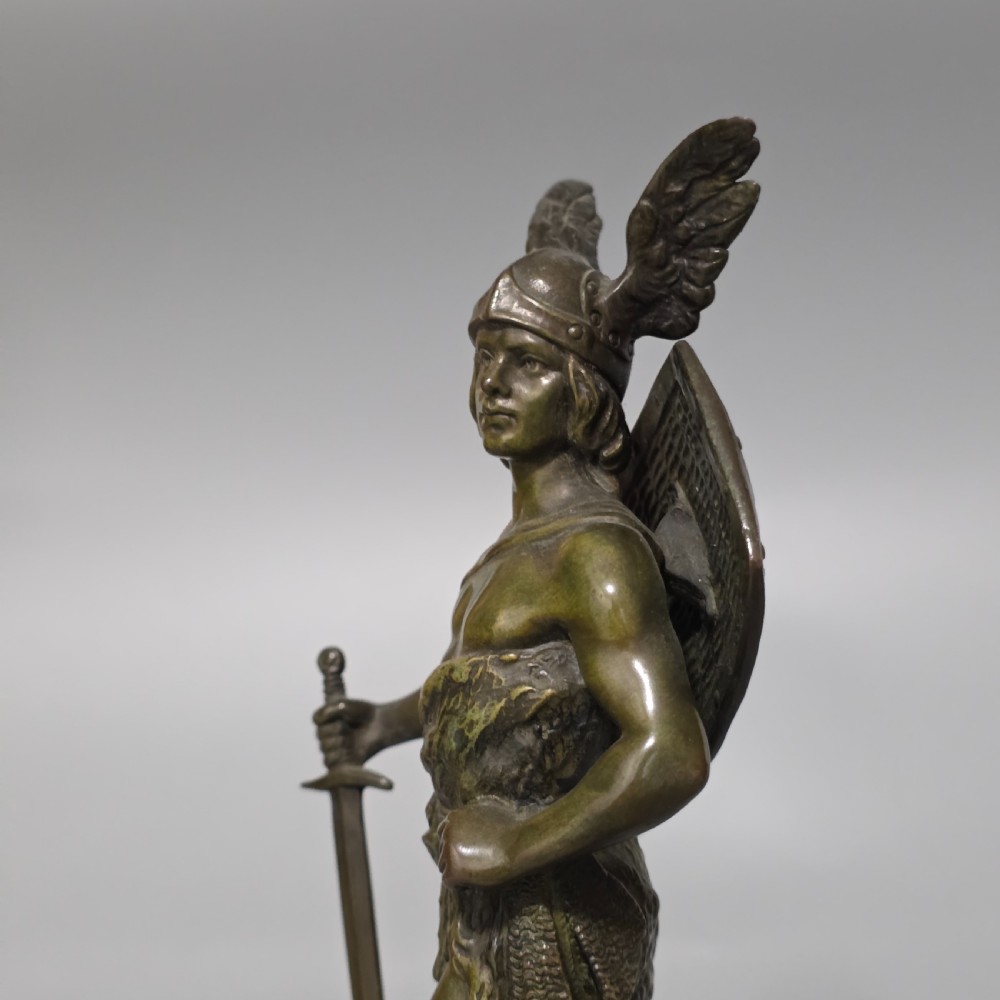 A patinated bronze sculpture depicting the mythical hero Siegfried standing victorious with a sword, winged helmet, and shield above a dragon base. View XVII