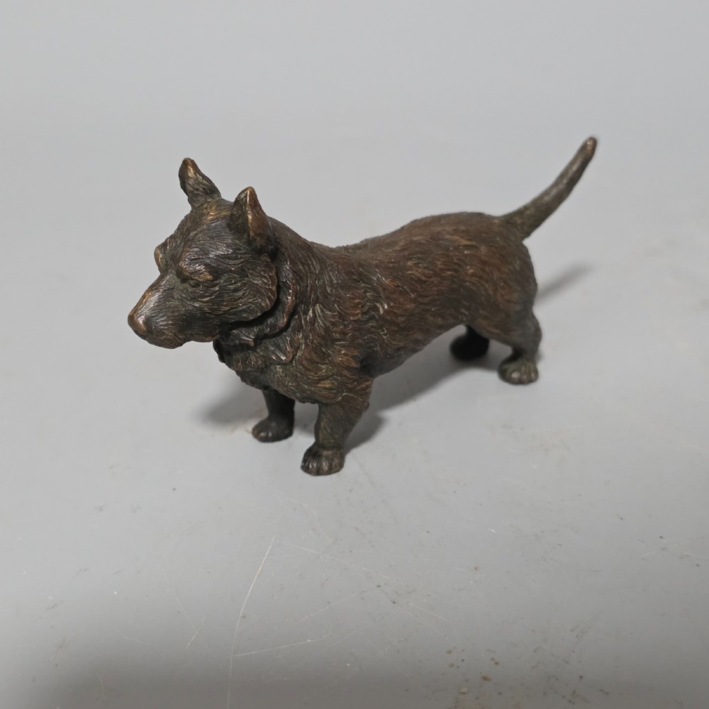 A small early twentieth-century Austrian bronze dog figurine standing with pricked ears and textured fur detail.