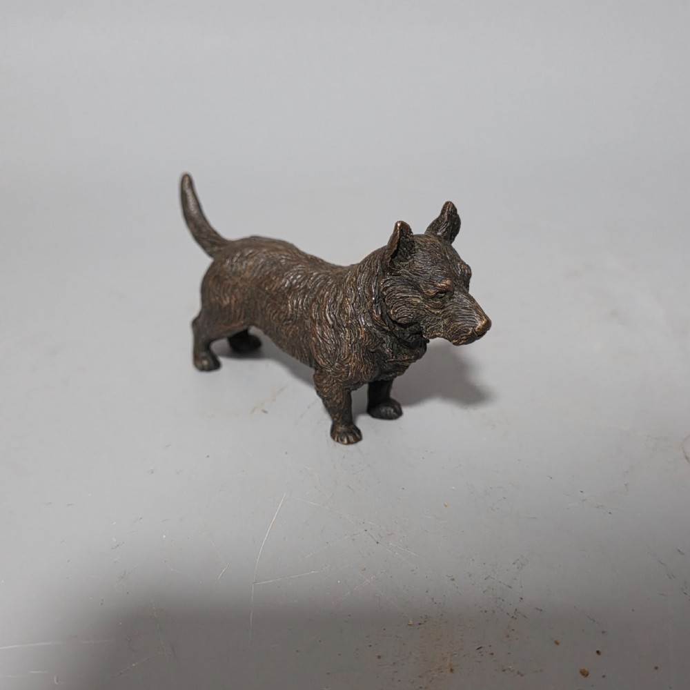 A small early twentieth-century Austrian bronze dog figurine standing with pricked ears and textured fur detail. View II