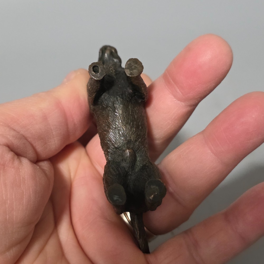 A small early twentieth-century Austrian bronze dog figurine standing with pricked ears and textured fur detail. View IX