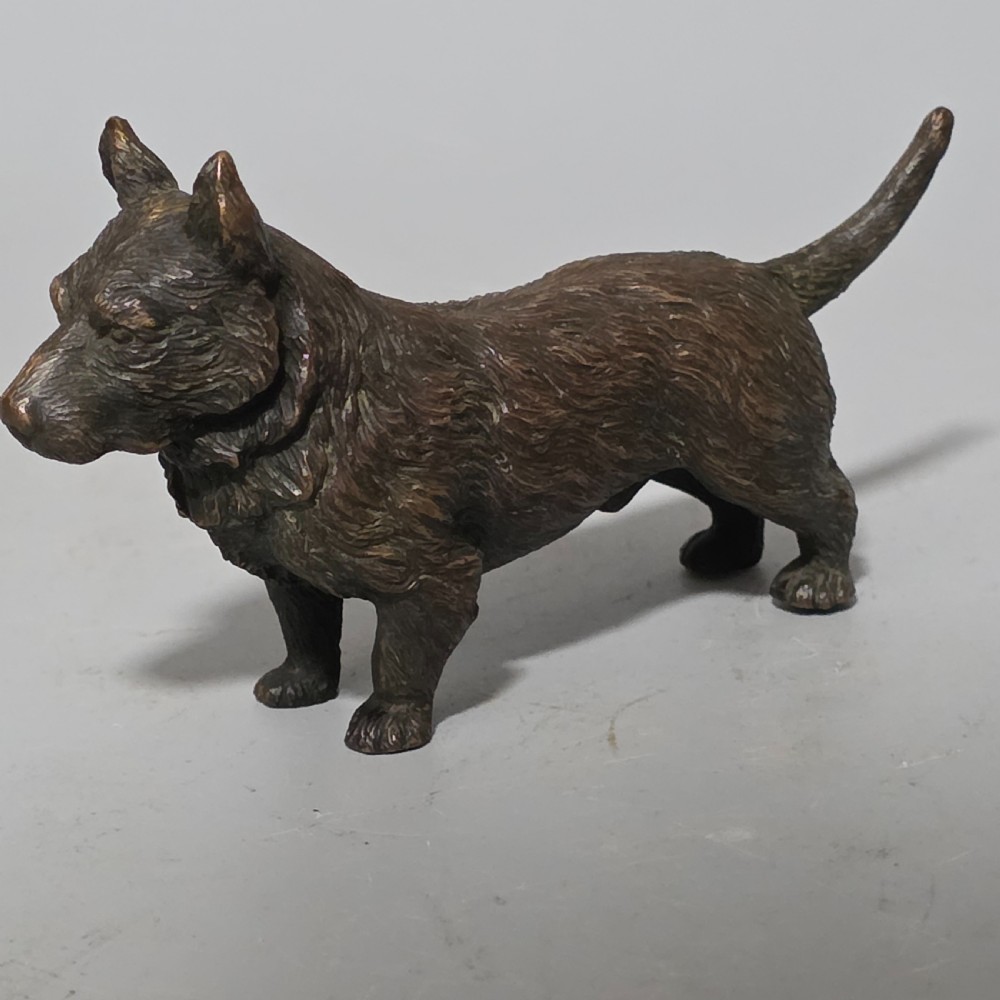 A small early twentieth-century Austrian bronze dog figurine standing with pricked ears and textured fur detail. View XVI
