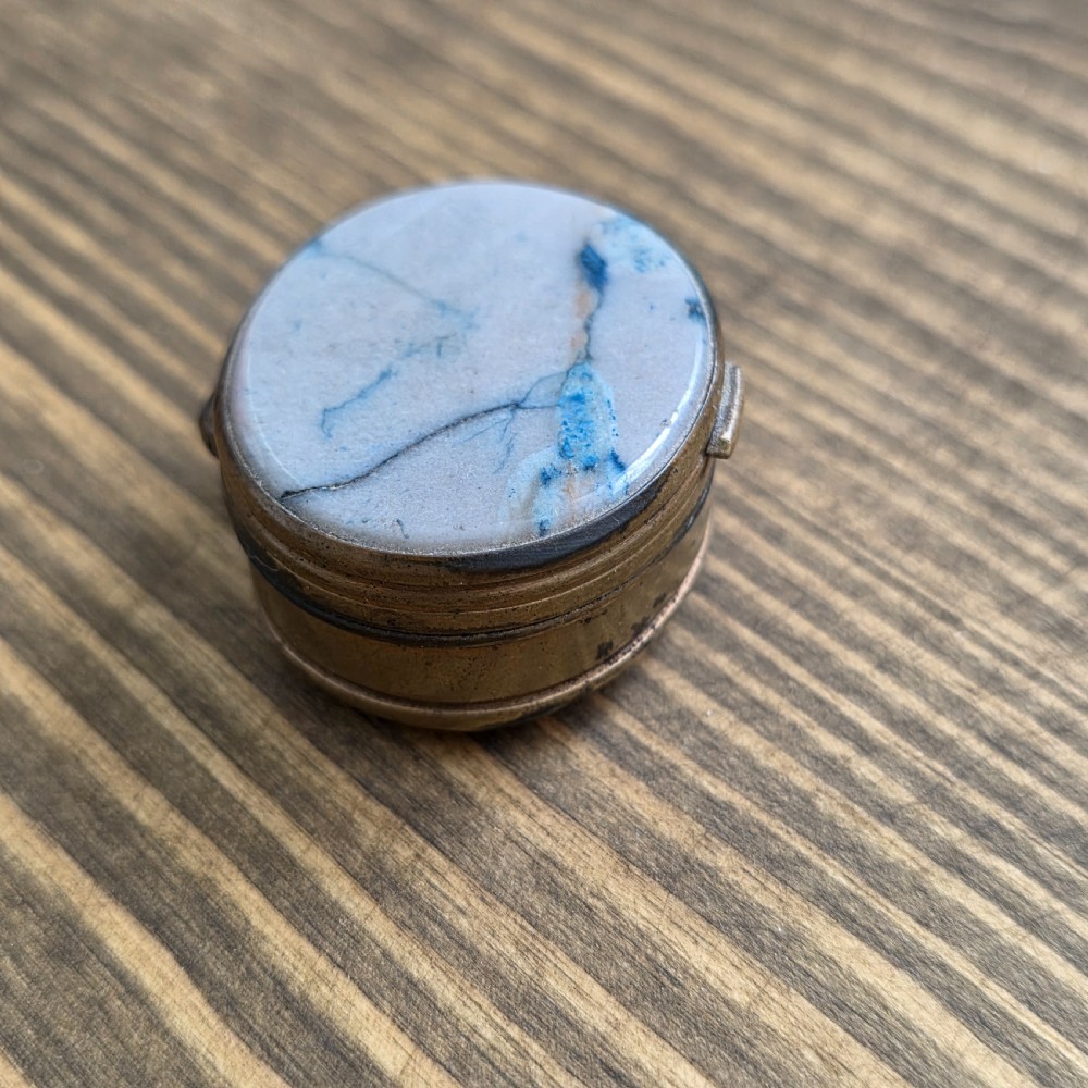 An oval Georgian gilt metal snuff box featuring a polished blue and grey banded agate stone inset on the lid. View II