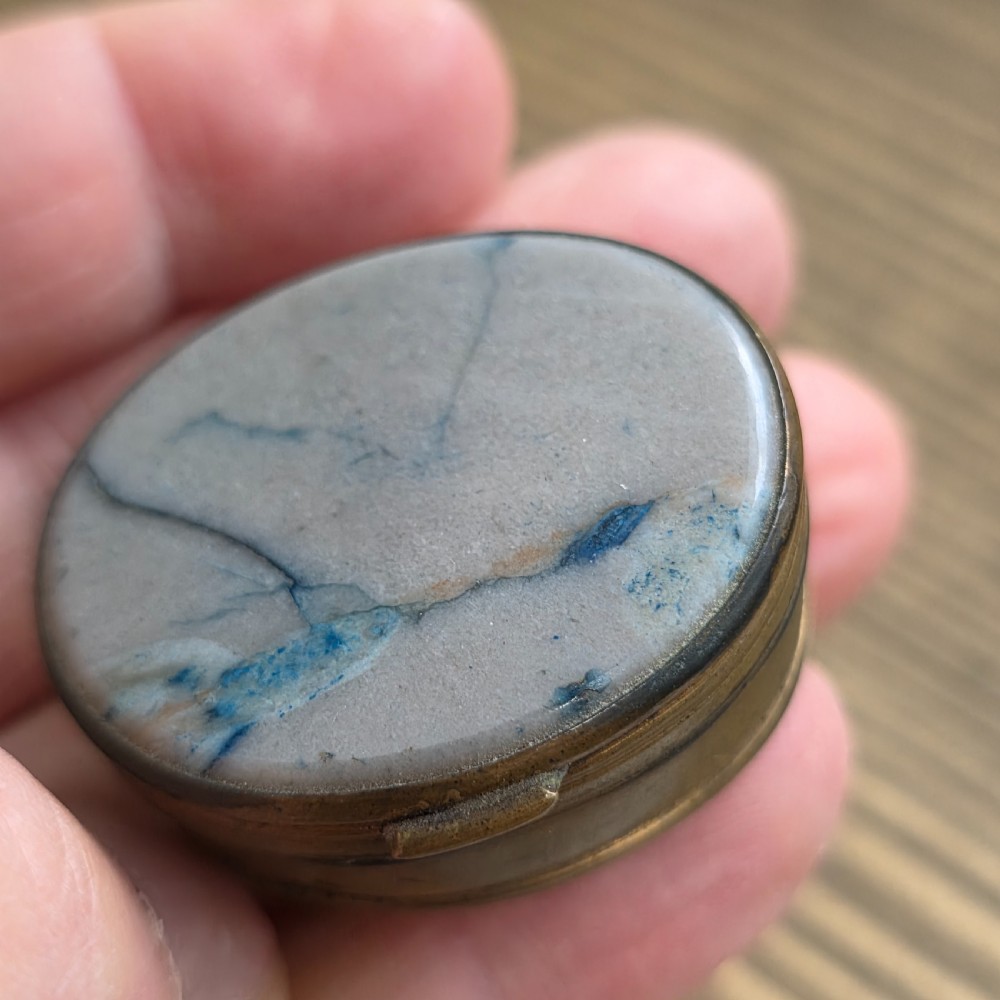 An oval Georgian gilt metal snuff box featuring a polished blue and grey banded agate stone inset on the lid. View VII