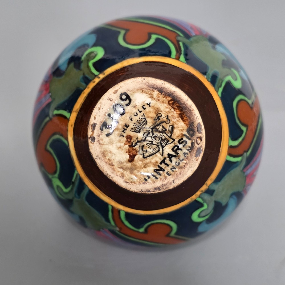 A glazed earthenware Art Nouveau vase with twin handles featuring a dark blue and brown ground decorated with stylised pink, purple, yellow, and green floral patterns. View IX