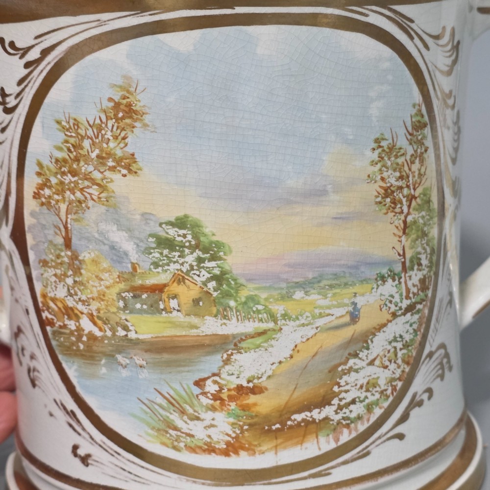 A nineteenth-century ceramic loving cup featuring two side handles, gilt trim, and a hand-painted landscape scene inside an oval cartouche. View VII