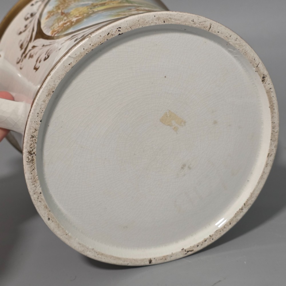 A nineteenth-century ceramic loving cup featuring two side handles, gilt trim, and a hand-painted landscape scene inside an oval cartouche. View IX
