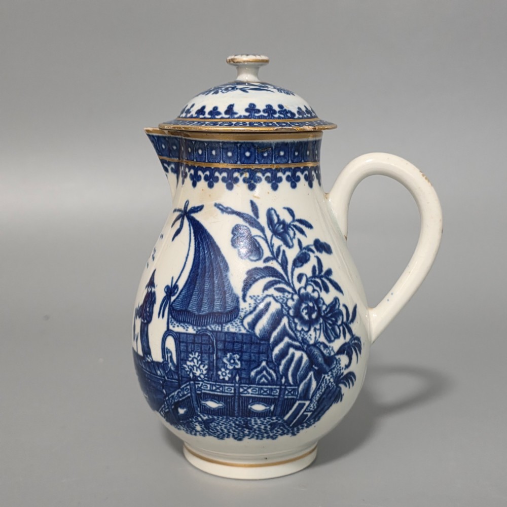 An 18th-century Worcester First Period soft-paste porcelain sparrow beak jug with cover, featuring a blue and white chinoiserie pattern and gilded rims.