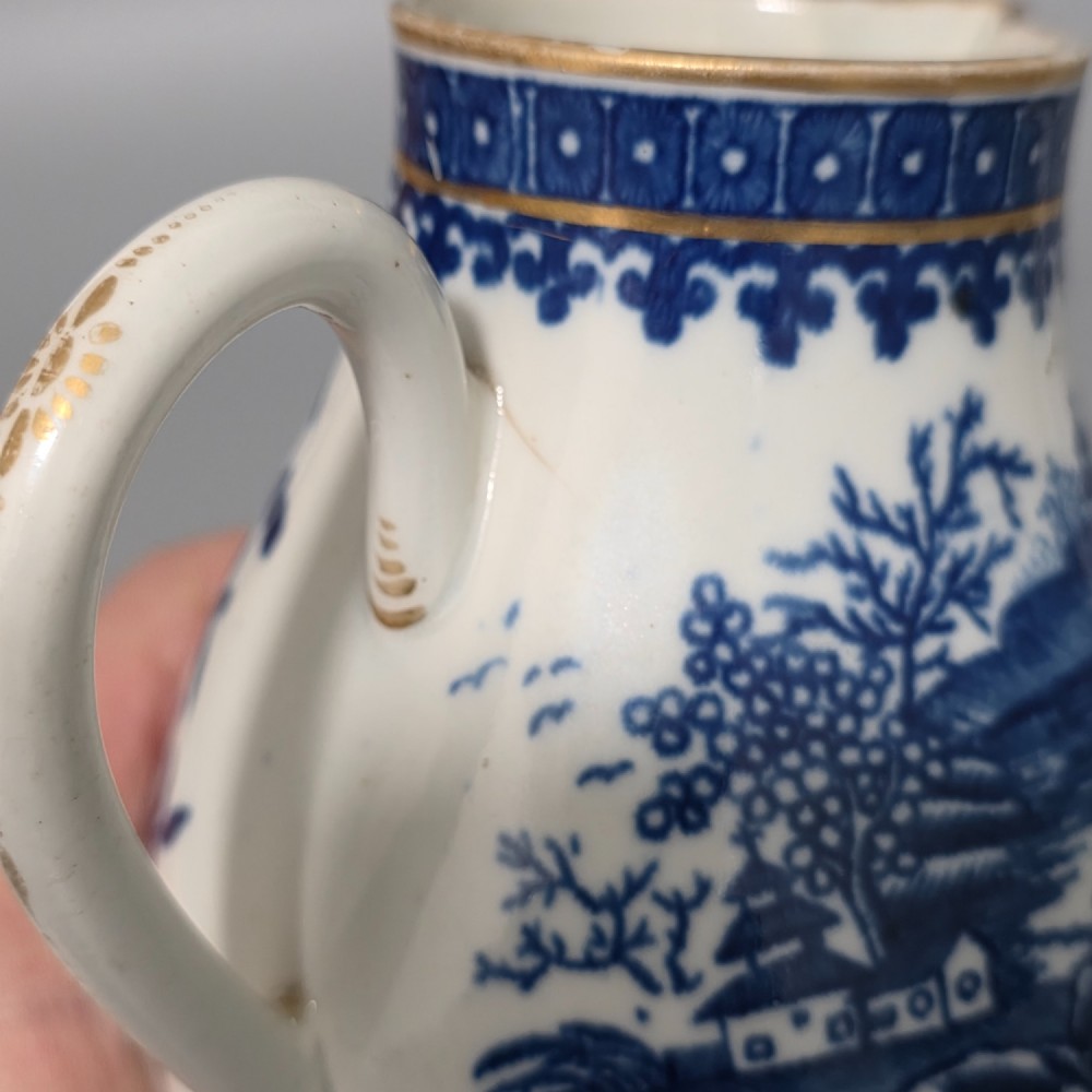 An 18th-century Worcester First Period soft-paste porcelain sparrow beak jug with cover, featuring a blue and white chinoiserie pattern and gilded rims. View VI