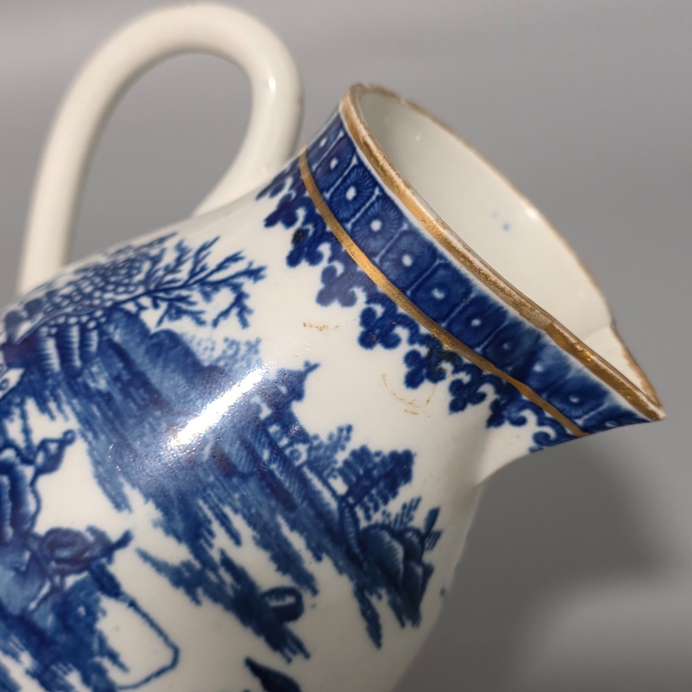An 18th-century Worcester First Period soft-paste porcelain sparrow beak jug with cover, featuring a blue and white chinoiserie pattern and gilded rims. View X