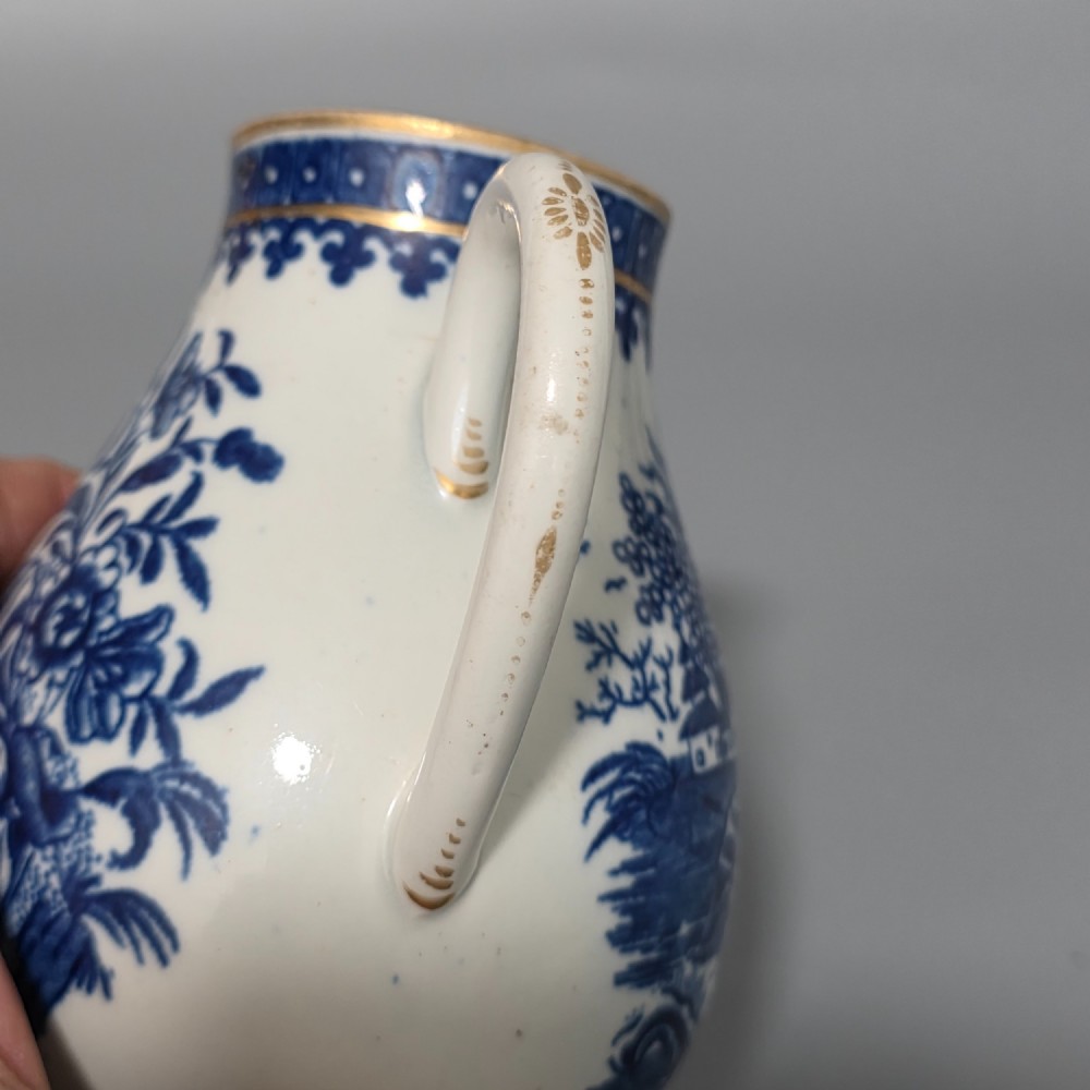 An 18th-century Worcester First Period soft-paste porcelain sparrow beak jug with cover, featuring a blue and white chinoiserie pattern and gilded rims. View XI