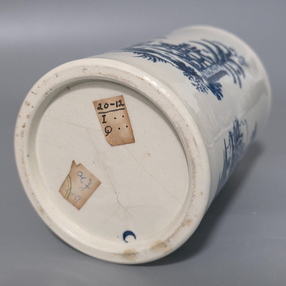 A tall cylindrical white porcelain mug featuring an 18th-century blue underglaze transfer-printed Chinoiserie design of figures and parasols with a single loop handle. View XI