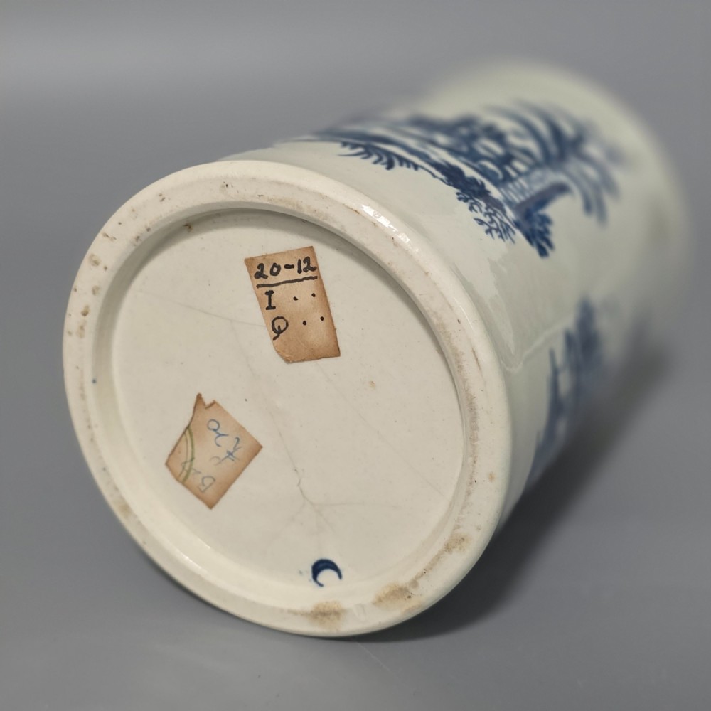 A tall cylindrical white porcelain mug featuring an 18th-century blue underglaze transfer-printed Chinoiserie design of figures and parasols with a single loop handle. View XII