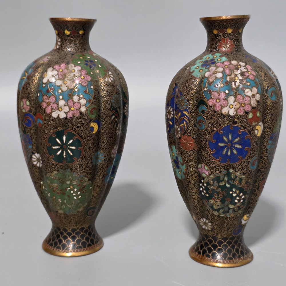 A pair of baluster-shaped Japanese cloisonne enamel vases decorated with intricate floral patterns, roundels, and scrollwork on a dark ground. View II