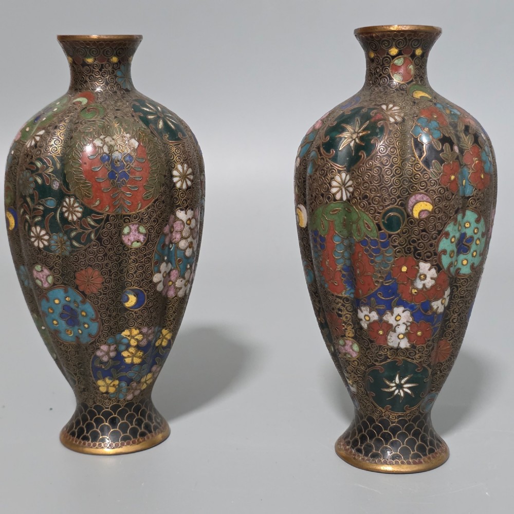 A pair of baluster-shaped Japanese cloisonne enamel vases decorated with intricate floral patterns, roundels, and scrollwork on a dark ground. View III