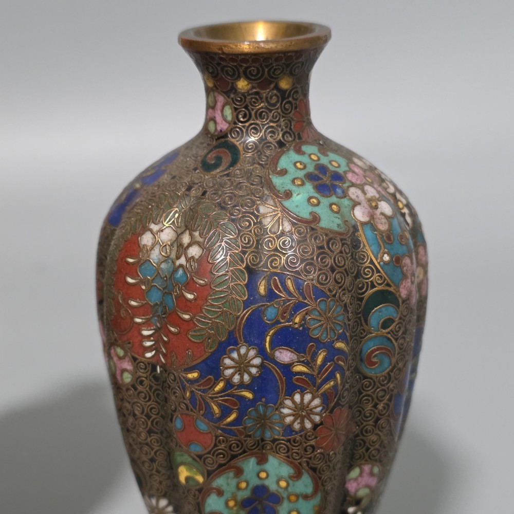 A pair of baluster-shaped Japanese cloisonne enamel vases decorated with intricate floral patterns, roundels, and scrollwork on a dark ground. View V