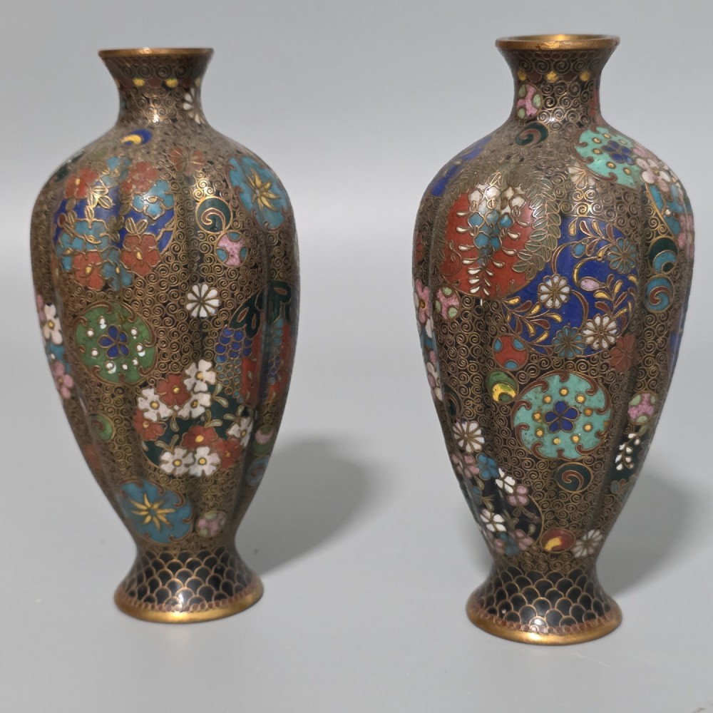 A pair of baluster-shaped Japanese cloisonne enamel vases decorated with intricate floral patterns, roundels, and scrollwork on a dark ground. View VI