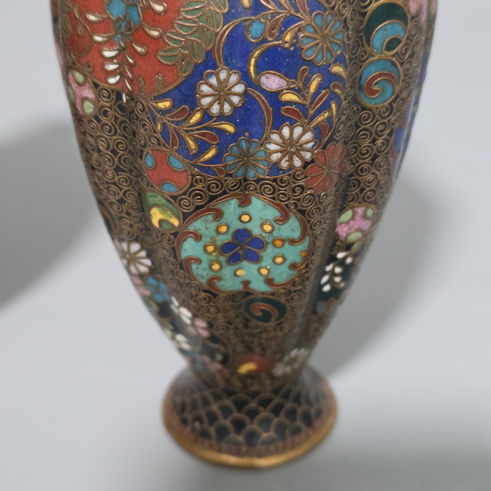 A pair of baluster-shaped Japanese cloisonne enamel vases decorated with intricate floral patterns, roundels, and scrollwork on a dark ground. View VII