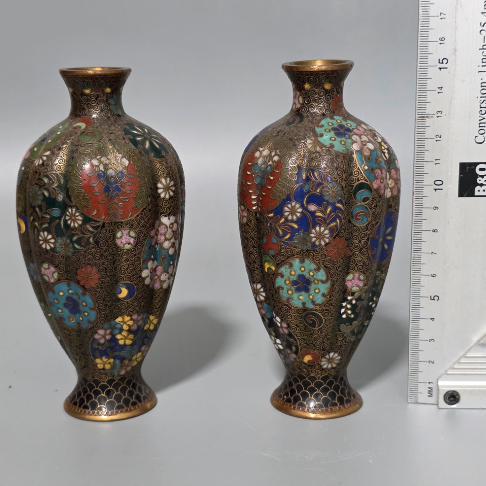 A pair of baluster-shaped Japanese cloisonne enamel vases decorated with intricate floral patterns, roundels, and scrollwork on a dark ground. View VIII