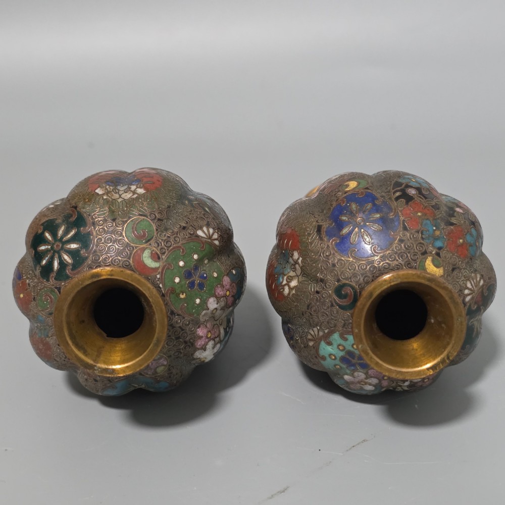 A pair of baluster-shaped Japanese cloisonne enamel vases decorated with intricate floral patterns, roundels, and scrollwork on a dark ground. View IX