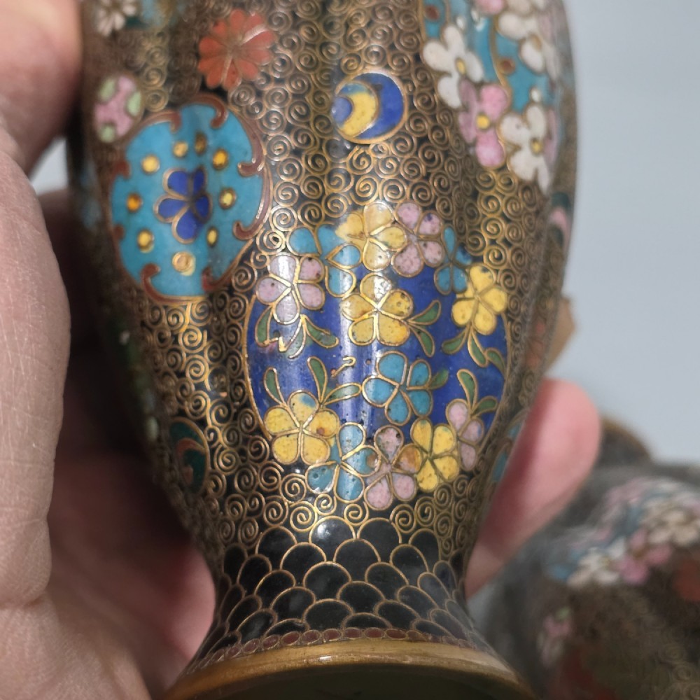 A pair of baluster-shaped Japanese cloisonne enamel vases decorated with intricate floral patterns, roundels, and scrollwork on a dark ground. View XII