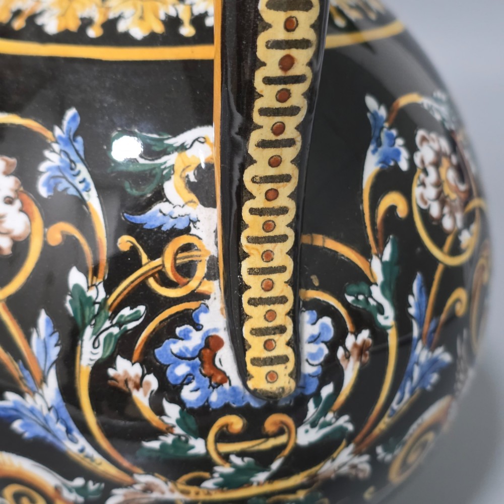 A nineteenth-century French Gien faience water pitcher featuring a black glazed body decorated with hand-painted ochre, white, and blue Renaissance revival mythological figures and scrolling foliage. View IV