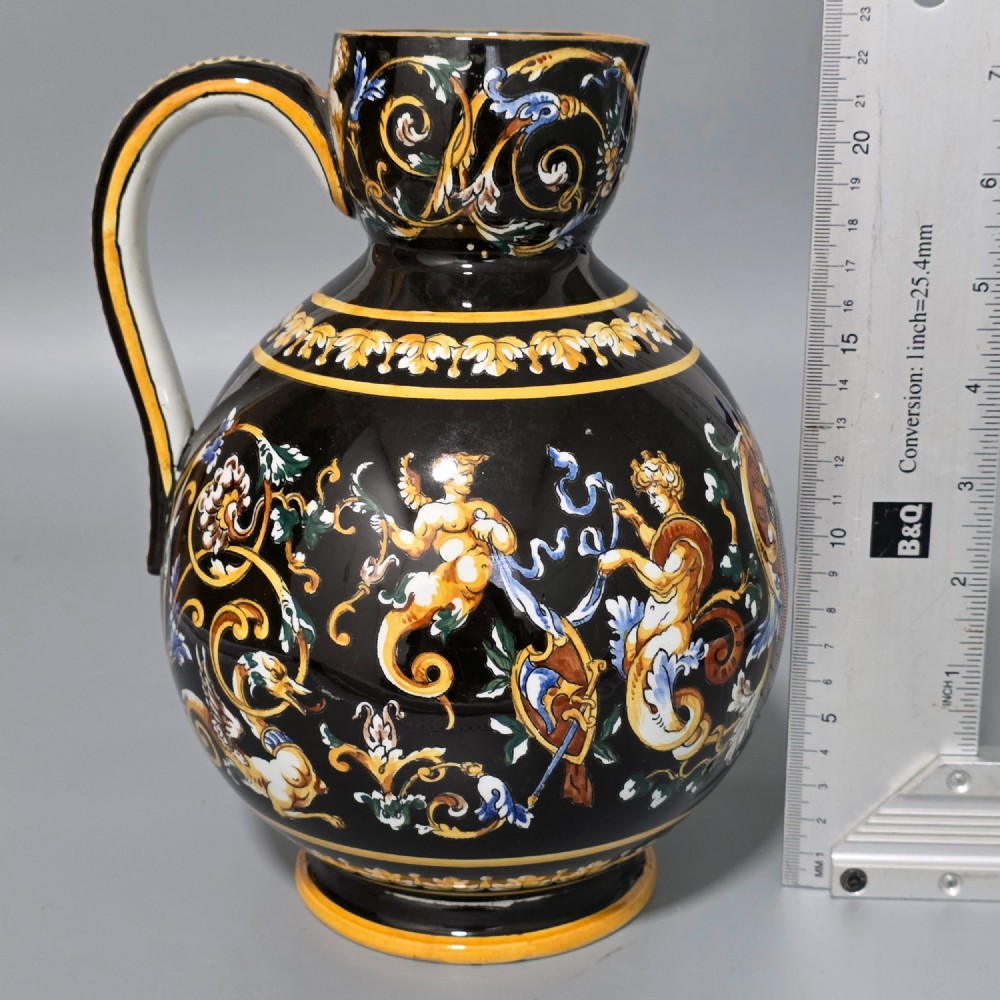 A nineteenth-century French Gien faience water pitcher featuring a black glazed body decorated with hand-painted ochre, white, and blue Renaissance revival mythological figures and scrolling foliage. View VII