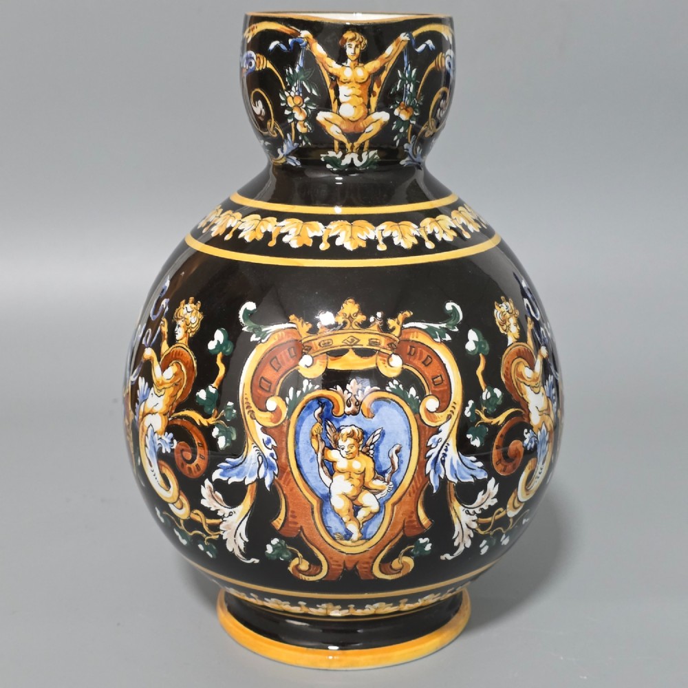 A nineteenth-century French Gien faience water pitcher featuring a black glazed body decorated with hand-painted ochre, white, and blue Renaissance revival mythological figures and scrolling foliage. View IX