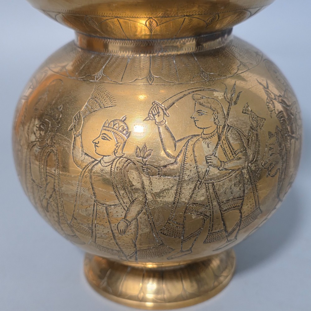 An antique Indian engraved brass kamandal vessel featuring a rounded base decorated with figures, a flared upper rim, and a high arched handle with raised knops. View XI